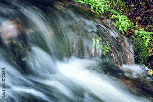 Beautiful stream of water, waterfall, stones, green grass