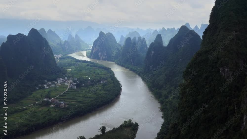 Beautiful Chinese natural landscape with karst hills, mountains, town and countryside between Yangshuo and Guilin, China, Asia. Tourist cruise ships on Li River, seen from Xianggong Hill viewpoint