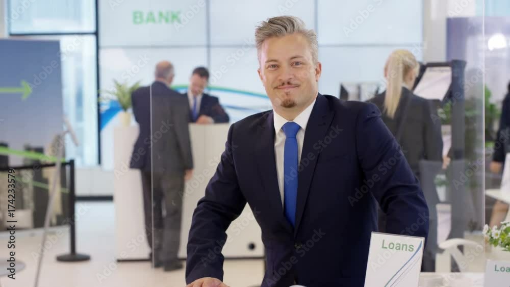 Portrait of friendly smiling financial adviser at customer help desk in bank Portrait of friendly smiling financial adviser at customer help desk in bank
