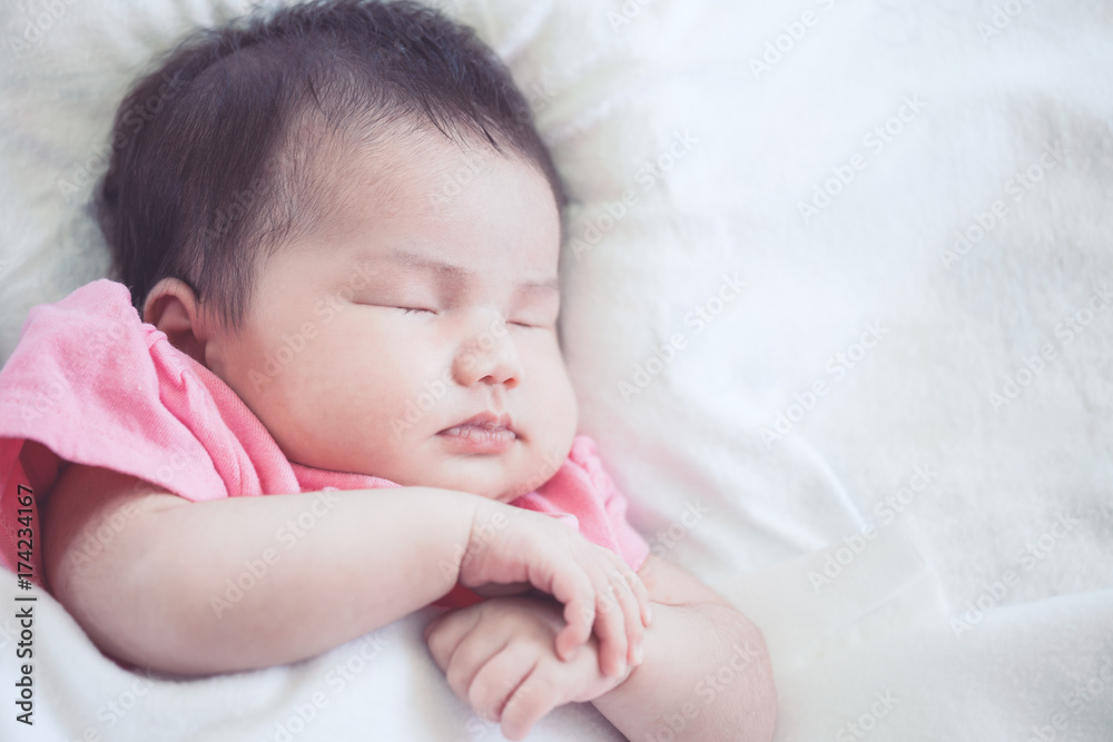 Asian newborn baby girl sleeping on white bed Asian newborn baby girl sleeping on white bed