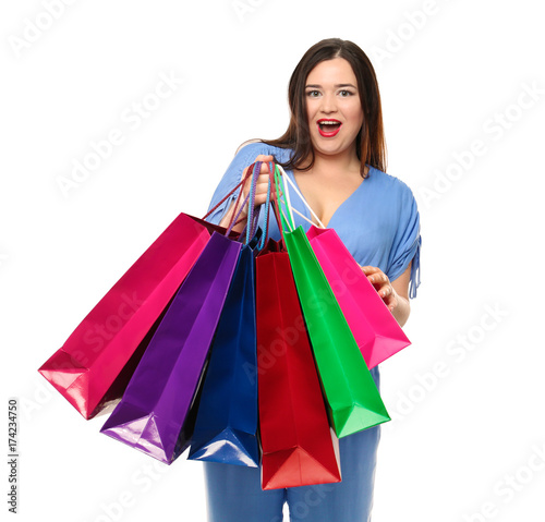 Beautiful stylish overweight woman with shopping bags on white background