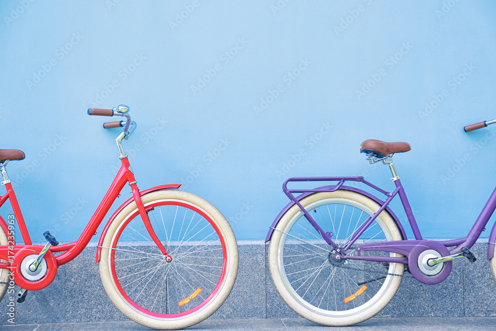 Fototapeta premium Stylish new bicycles near color wall outdoors