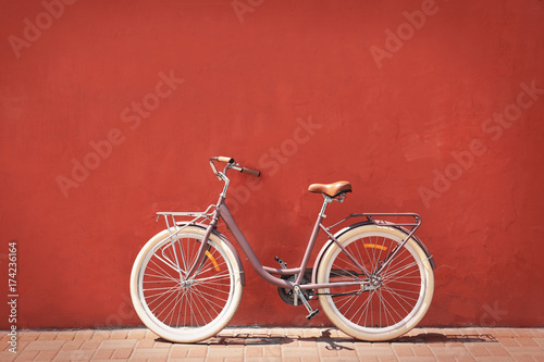 Stylish new bicycle near color wall outdoors