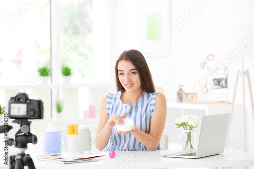 Young female blogger with c...