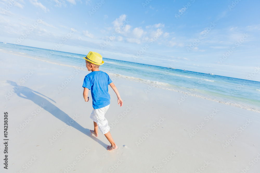 Boy having fun on tropical ocean beach. Kid during family sea vacation.