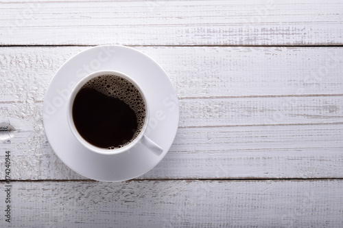 Cup of coffee on white table. Black coffee topview