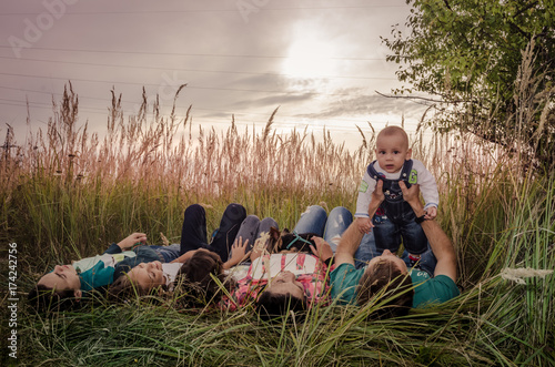 Obraz na płótnie Happy young family spending time together outside in green nature. w salonie