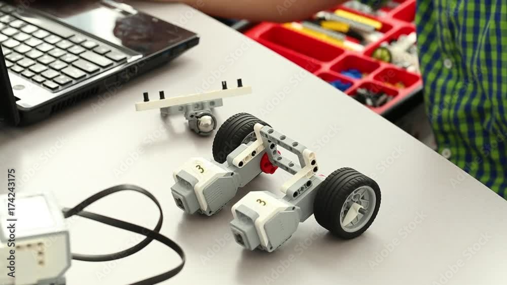 Closeup view of hands of young child constructing modern robots first and programming their actions on laptops. Kids learning to make robots. Real time full hd video footage. Closeup view of hands of young child constructing modern robots first and programming their actions on laptops. Kids learning to make robots. Real time full hd video footage.