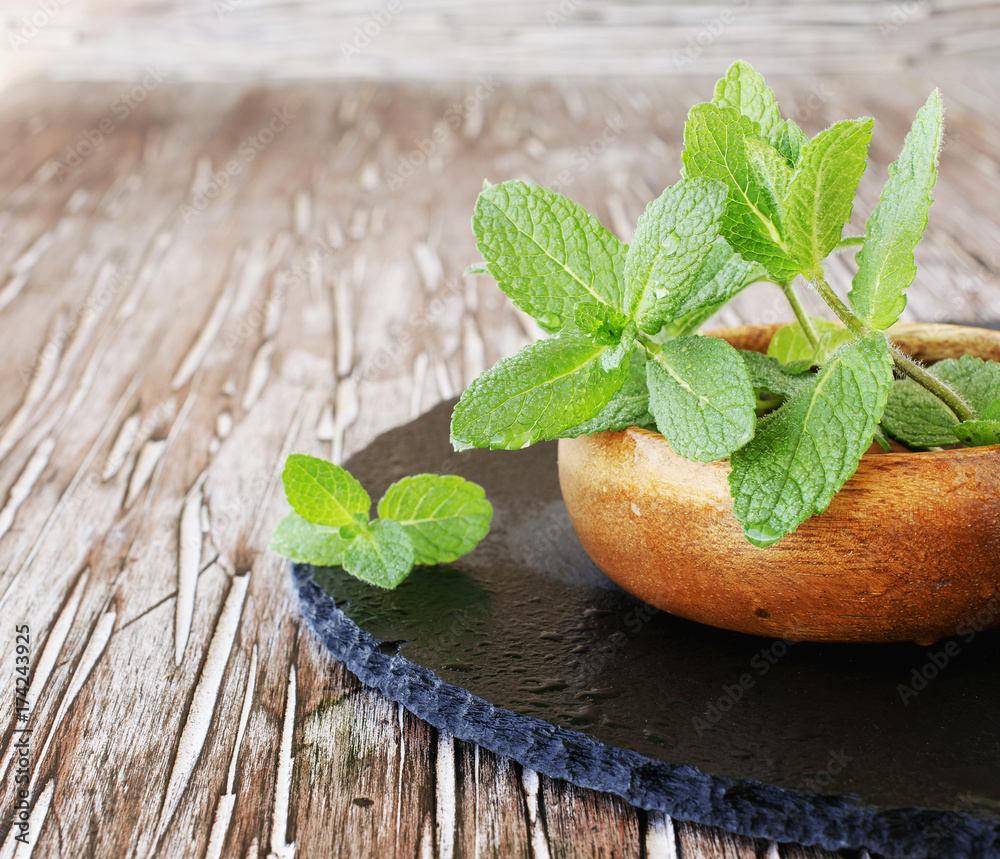 Fresh mint in a wooden bowl, selective focus Fresh mint in a wooden bowl, selective focus