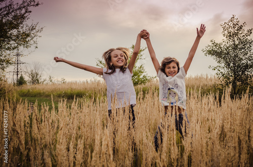 Obraz na płótnie Two happy kids jumping outside. Happy childhood w salonie