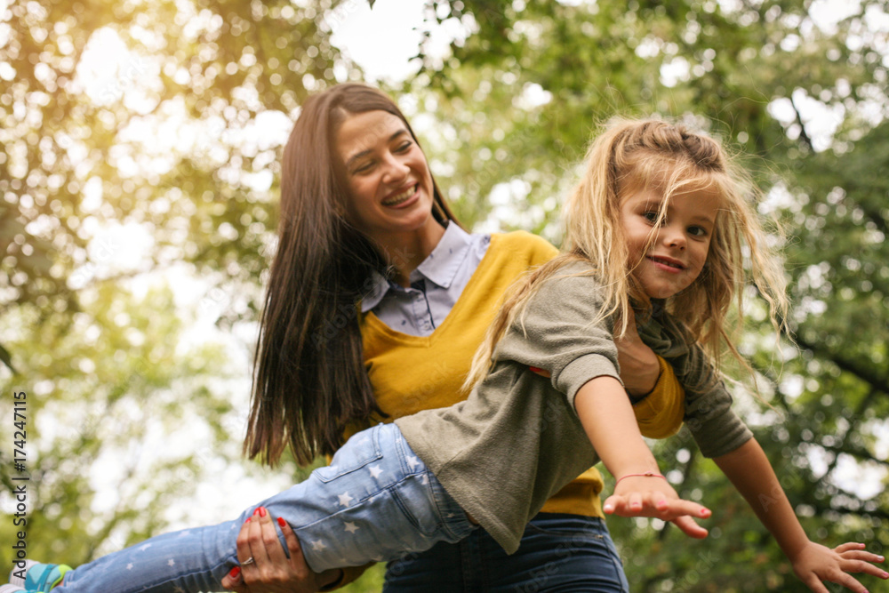 Mother and daughter ion meadow. Mother holding his daughter in hands.