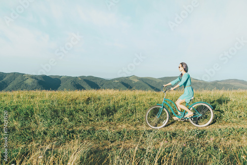 Beautiful woman in dress riding bicycle.