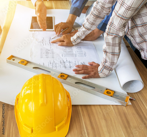 A group of engineers are looking at a blueprint for construction.