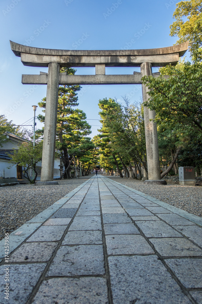 A Torii (gate of shrine) and a long stone paving way of Gokonomiya shrine in Kyoto, Japan