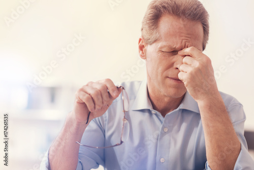 Depressed male office worker having aheadache