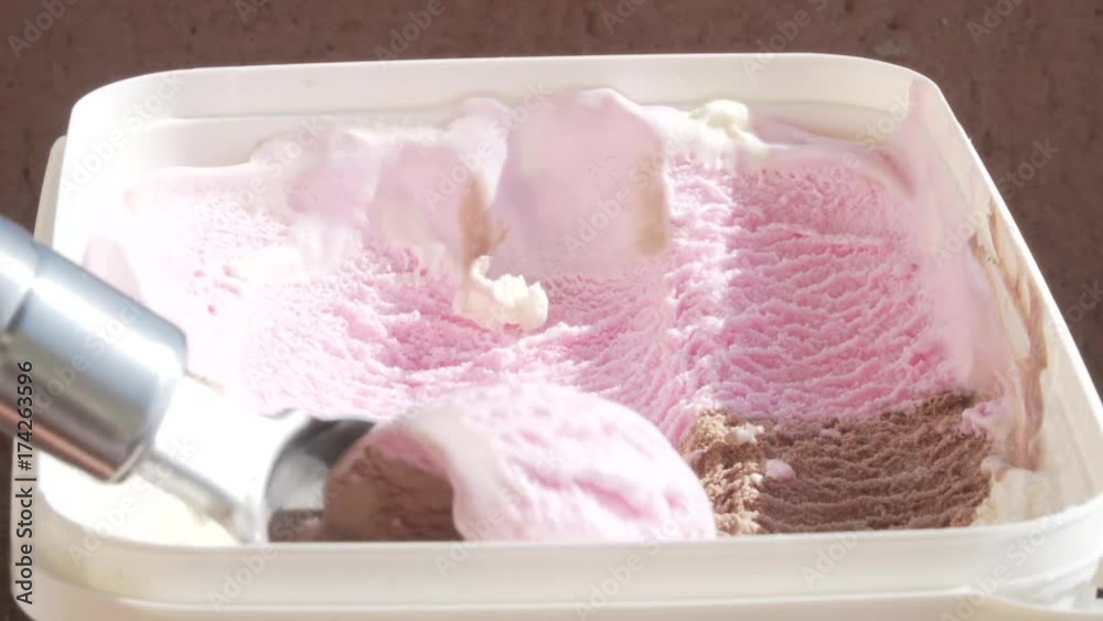 Three-colored ice cream being scooped out of container by a metal spoon. 4k Three-colored ice cream being scooped out of container by a metal spoon. 4k
