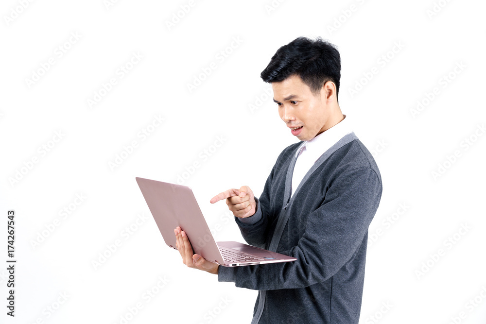 Young Asian male student in grey jacket pointing his finger at laptop isolated on white background Young Asian male student in grey jacket pointing his finger at laptop isolated on white background
