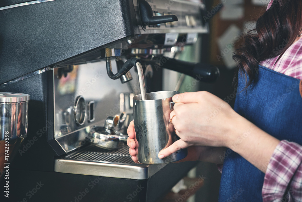 Female barista making coffee using machine