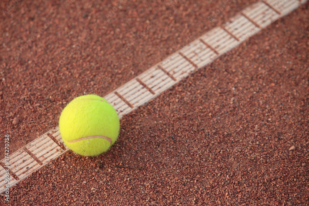 Tennis ball on the line, on clay court
