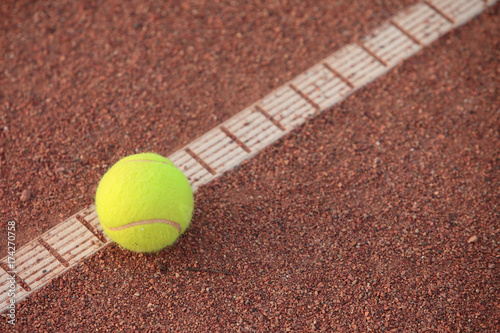 Tennis ball on the line, on clay court © cosbos