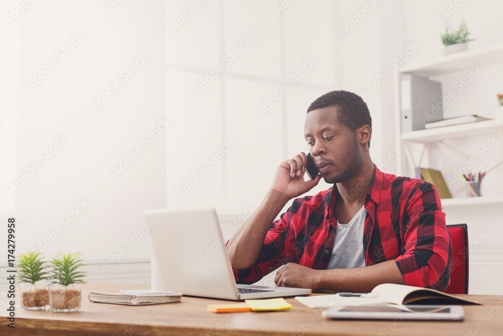 Young black businessman call mobile phone in modern white office Young black businessman call mobile phone in modern white office