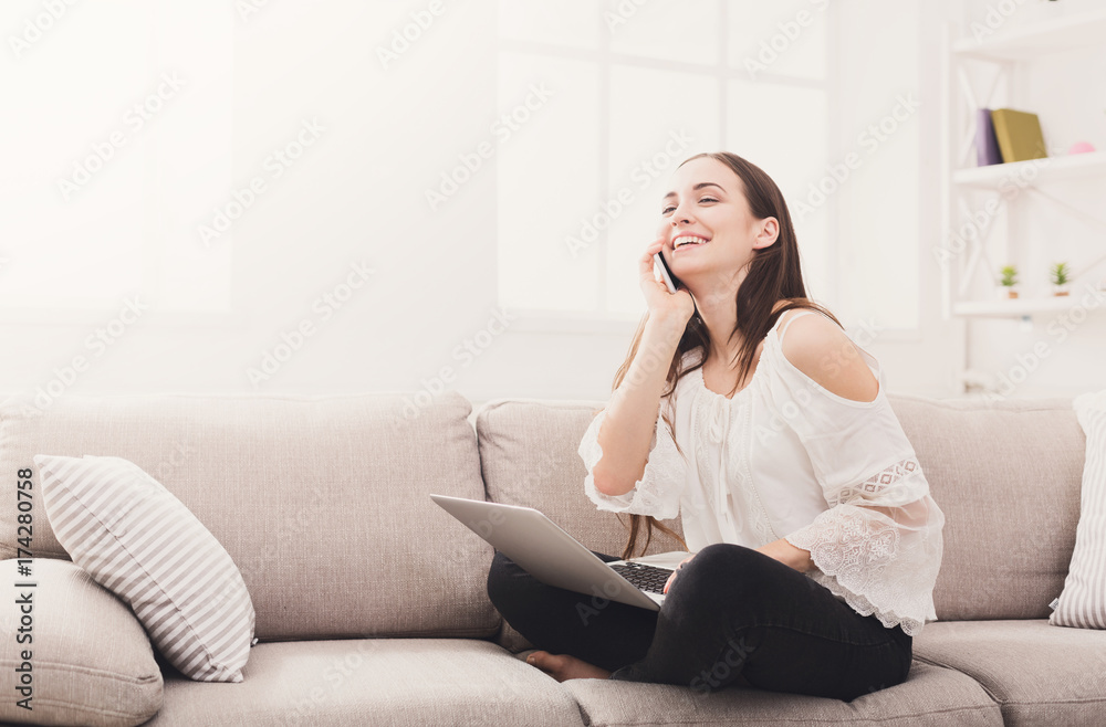 Young laughing woman at home with laptop and mobile Young laughing woman at home with laptop and mobile