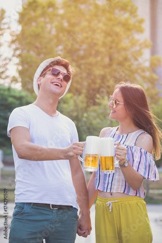 Couple toasting with beer outdoor