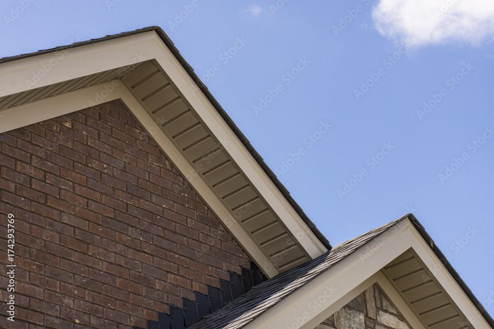 Roof showing soffit on the front of a brick and stone house.