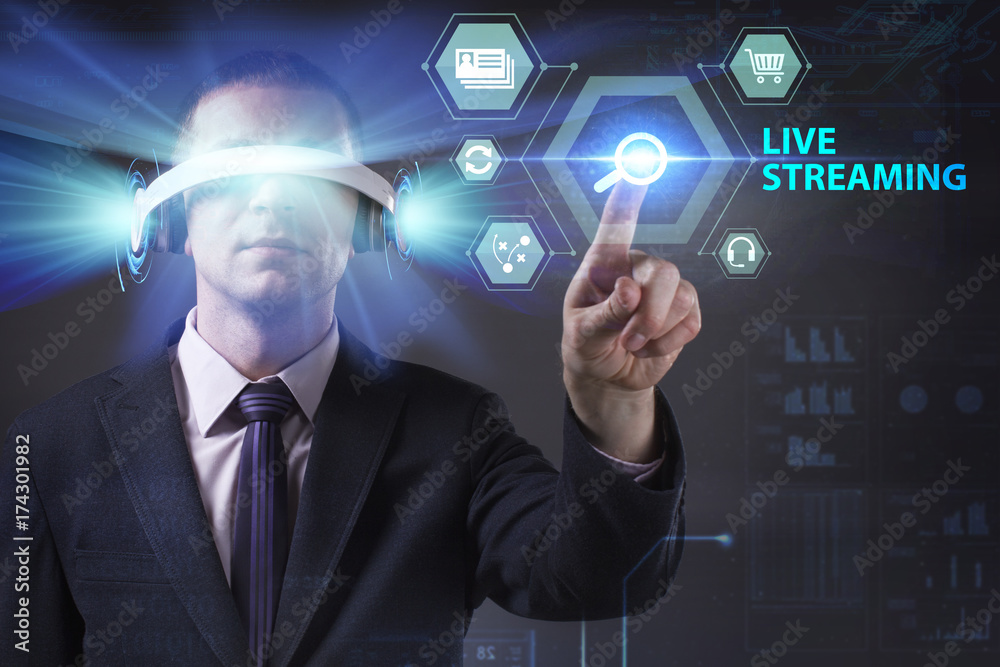 Business, Technology, Internet and network concept. Young businessman working in virtual reality glasses sees the inscription: Live streaming Business, Technology, Internet and network concept. Young businessman working in virtual reality glasses sees the inscription: Live streaming