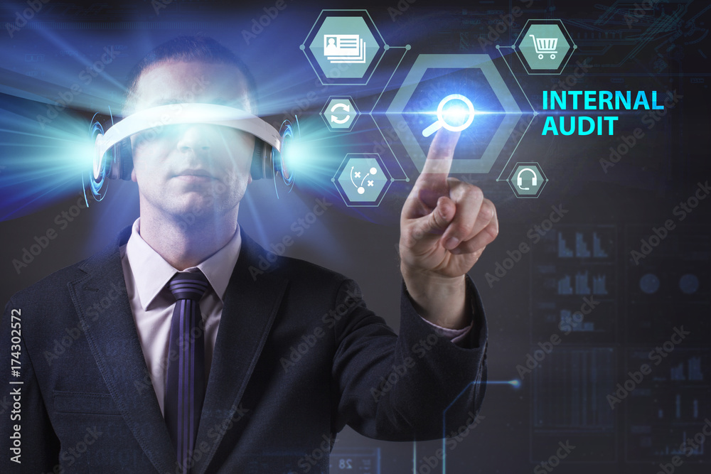 Business, Technology, Internet and network concept. Young businessman working in virtual reality glasses sees the inscription: Internal audit Business, Technology, Internet and network concept. Young businessman working in virtual reality glasses sees the inscription: Internal audit
