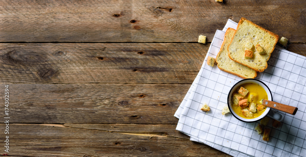 Cup of squash creamy vegetable vegetarian pumpkin carrot soup with bread crachers on wooden rustic background, copy space for your text Cup of squash creamy vegetable vegetarian pumpkin carrot soup with bread crachers on wooden rustic background, copy space for your text