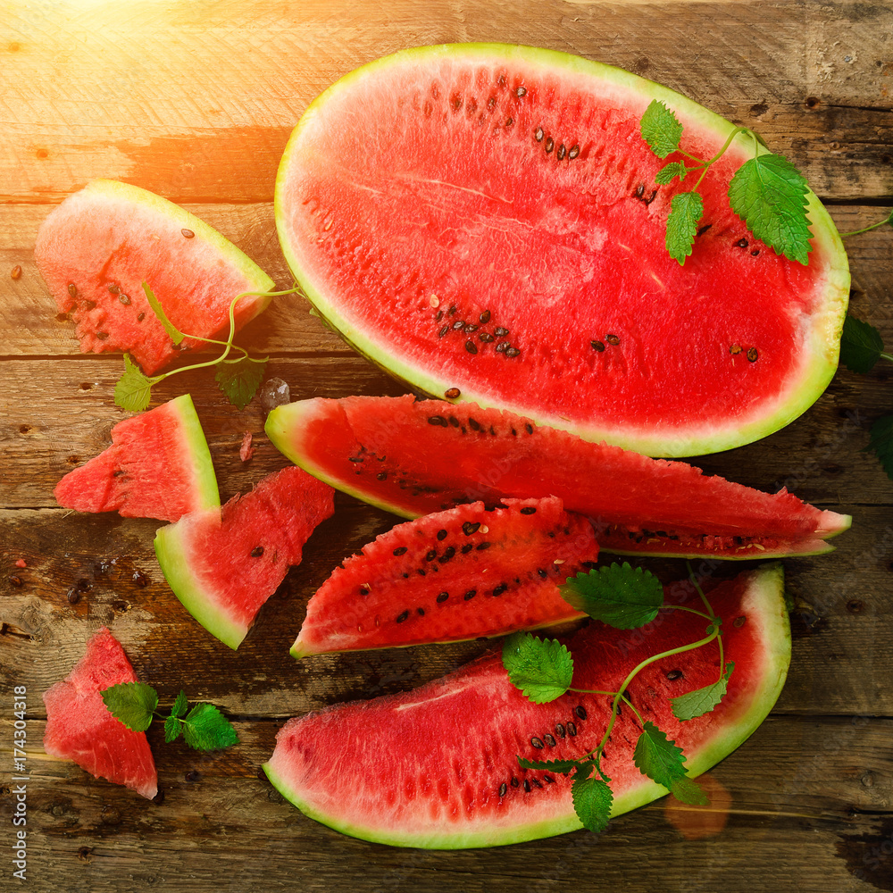 Slices of watermelon with mint leaves on wooden background. Detox and vegetarian concept. Top view, flat lay, copy space Slices of watermelon with mint leaves on wooden background. Detox and vegetarian concept. Top view, flat lay, copy space