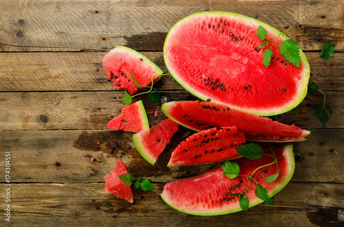 Slices of watermelon with mint leaves on wooden background. Detox and vegetarian concept. Top view, flat lay, copy space