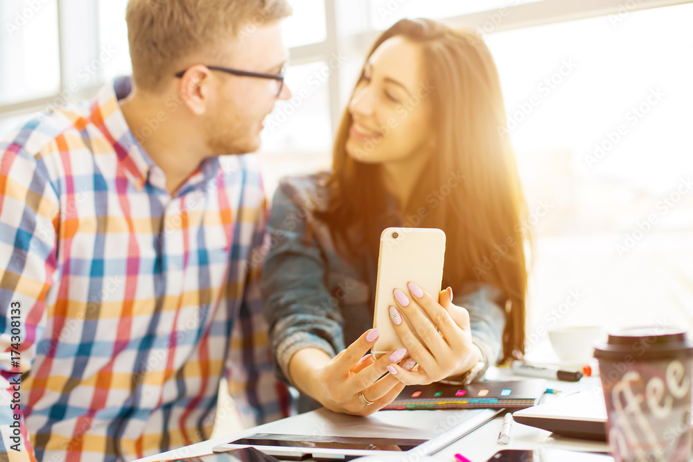 Obraz premium Two young creative designer colleagues using tablet at office