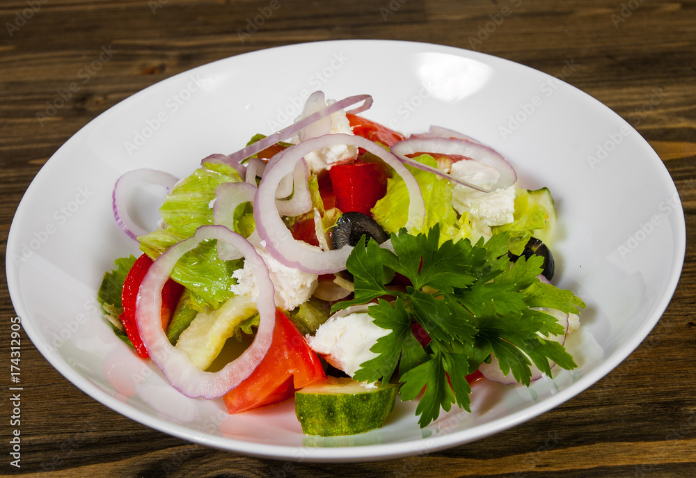 vegetable salad with cheese, cabbage, pepper, tomato and cucumber on wooden table. vegetable salad with cheese, cabbage, pepper, tomato and cucumber on wooden table.