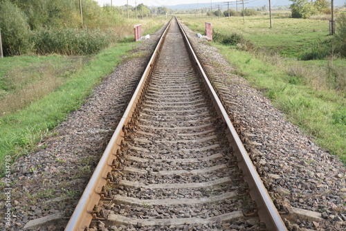 Railroad track winding through green forest