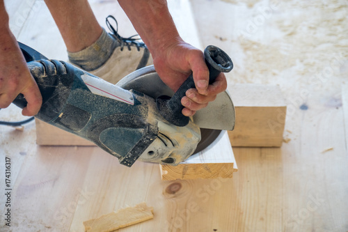 Man using a circular saw to cut floor material