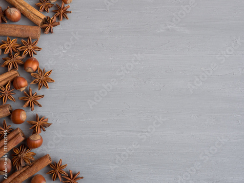 Fototapeta Naklejka Na Ścianę i Meble -  Cinnamon sticks spice star hazelnuts on a light background, the concrete Copy space