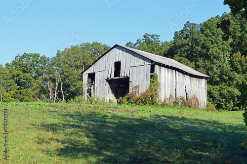 Photo of an old rustic abandoned barn in a rural landscape setting