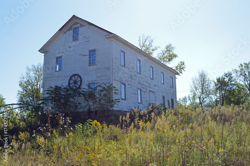 Photo of an old abandoned grain mill in a rural landscape settiing photo