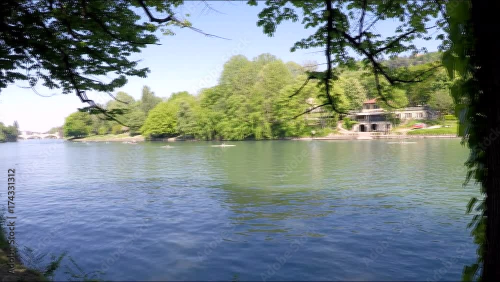 Horizontal pan over river in Turin, Italy and canoes or kayaks moving towards camera in a sunny day Horizontal pan over river in Turin, Italy and canoes or kayaks moving towards camera in a sunny day