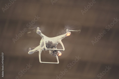 White drone quadcopter with digital camera flying 2
