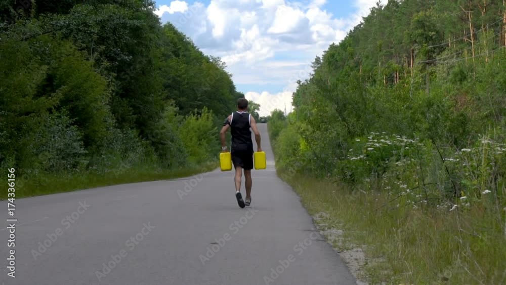 Man runs on the road with two yellow jerrycans