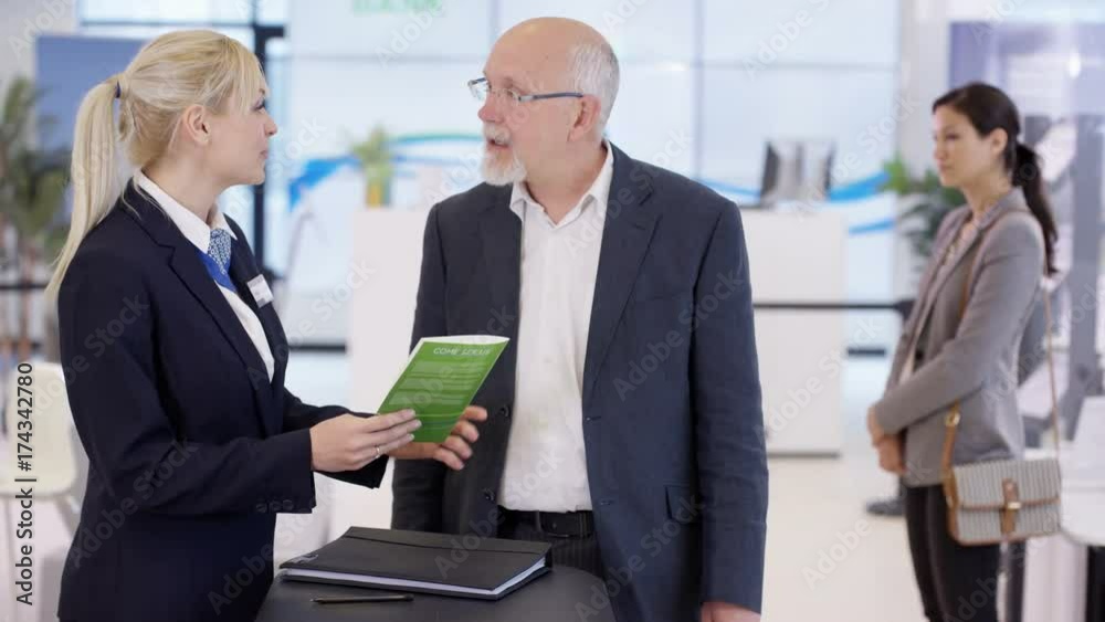Friendly bank workers talking to customers & offering financial advice Friendly bank workers talking to customers & offering financial advice