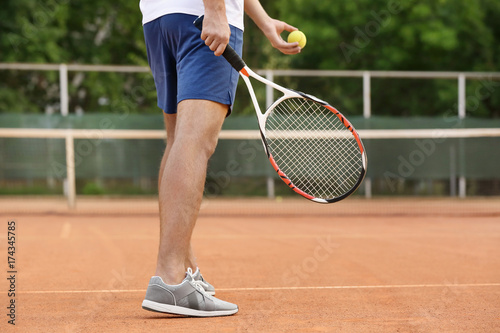 Young man playing tennis on court © Africa Studio