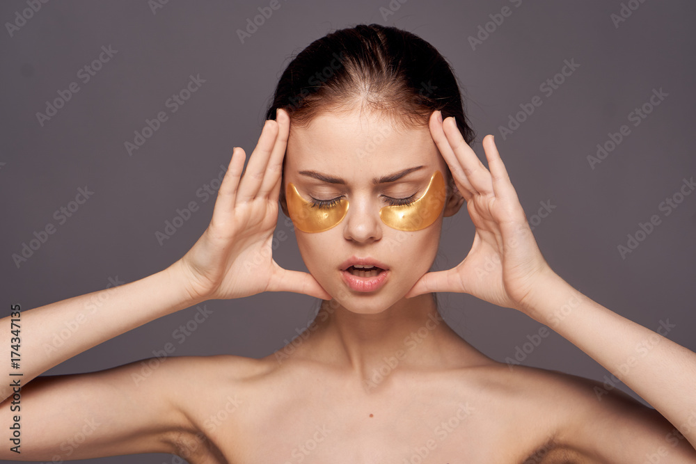 beautiful woman, golden patches for the eyes, black background beautiful woman, golden patches for the eyes, black background