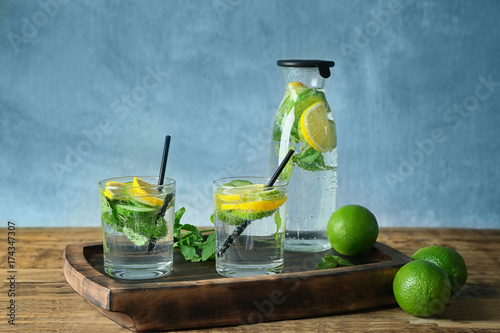 Glasses with detox infused cucumber water on wooden board