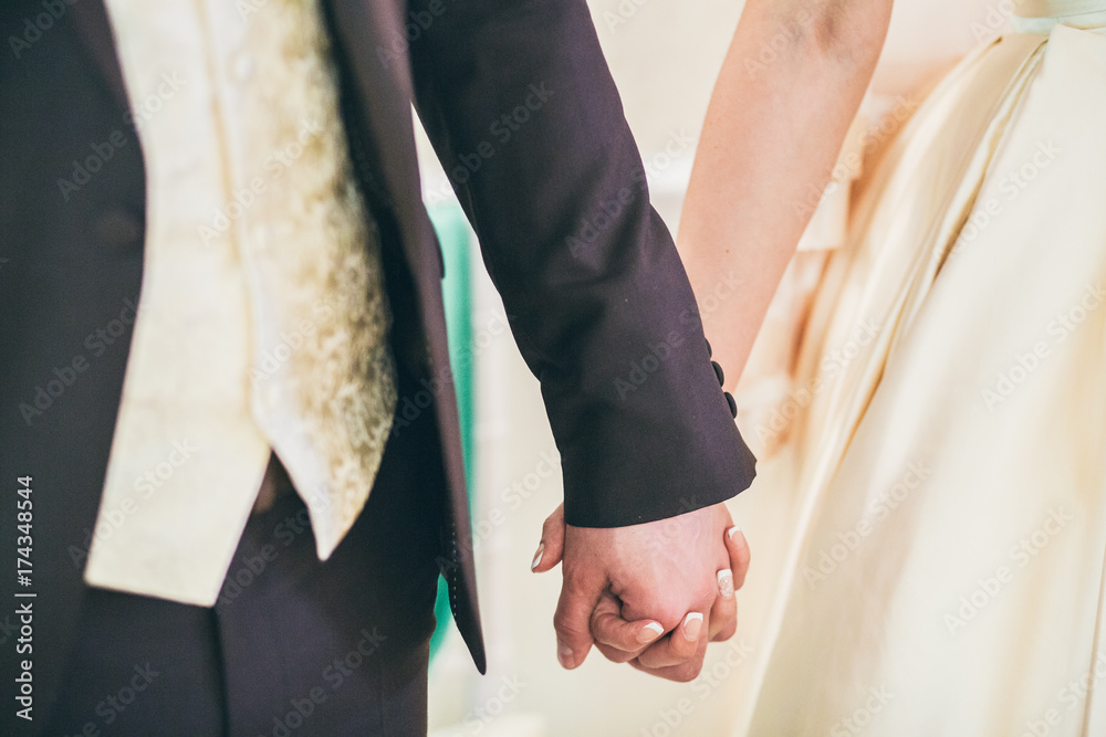 Fototapeta premium Groom and brides hands with rings, closeup view