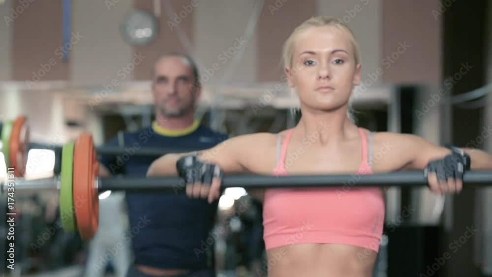 People do with a barbell in the gym. People do with a barbell in the gym.