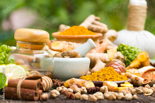 Turmeric powder,Turmeric in Mortar Grinder drugs and ingredient herbs on wooden background photo